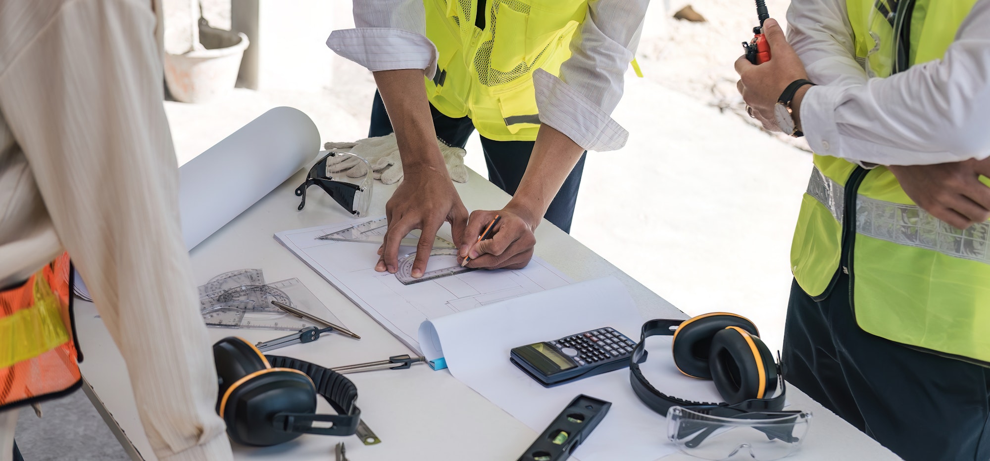 Civil engineer teams meeting working together wear worker helmets hardhat on construction site in